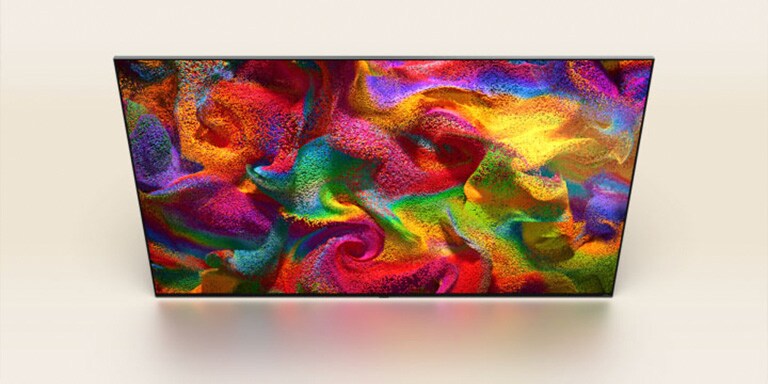 Farbpartikel explodieren auf dem Bildschirm, dann verwandeln sich die Pixel langsam in eine Nahaufnahme einer mit einem bunten Muster bemalten Wand auf dem Bildschirm des LG-Fernsehers.