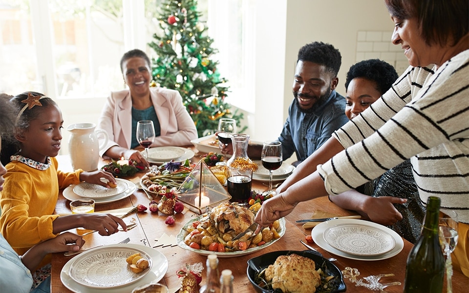 Eine Familie genießt ihr Abendessen, bevor sie ihre Urlaubsreste im Kühlschrank aufbewahrt.