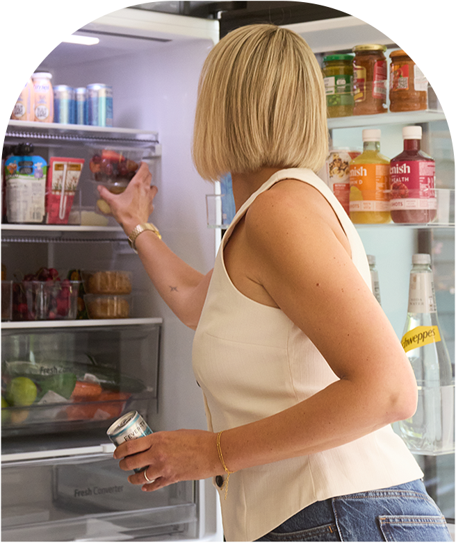 Eine Frau benutzt einen LG InstaView-Kühlschrank und eine Szene, die das Innere des Kühlschranks zeigt.