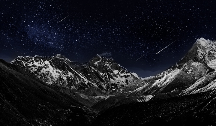 Mountain range with a dark evening sky filled with stars. The image is split in half, one side showing a duller, grayer version, the other side showing a more pleasing picture with greater dynamic range of blacks and whites. Logo certification is visible, Perfect Black Technology delivers black levels less than or equal to 0.24 nit up to 500 lux. 