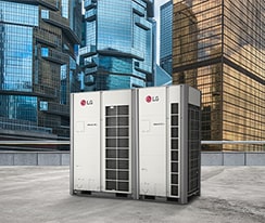 Two LG MULTI V i units stand side by side on a rooftop, front-facing view, against a backdrop of towering skyscrapers cloaked in the glass.