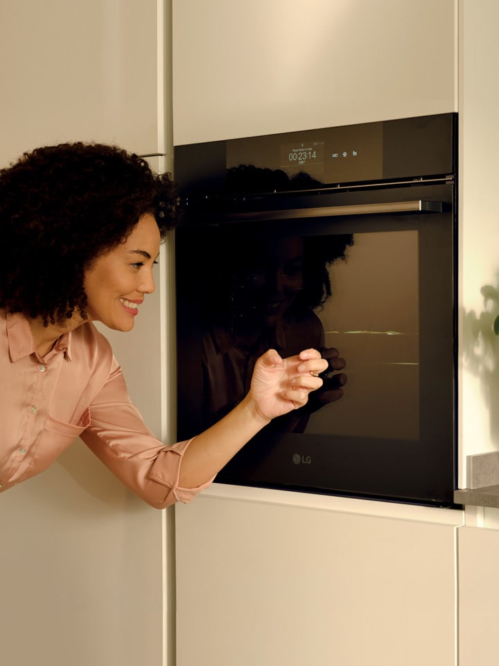 This is an image of a couple standing in kitchen.