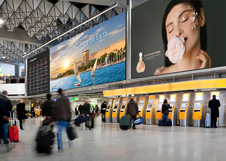 Large LEDs inside an airport show passengers’ departure schedules and advertisements.