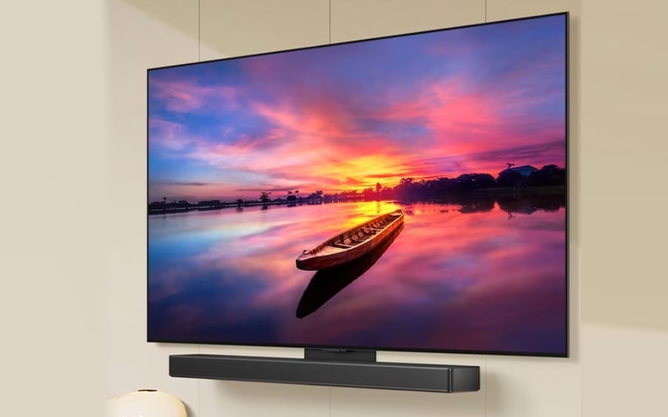 LG OLED TV with soundbar displaying a vivid sunset. Offers great picture quality and sound, ideal for gaming and cinematic experiences.