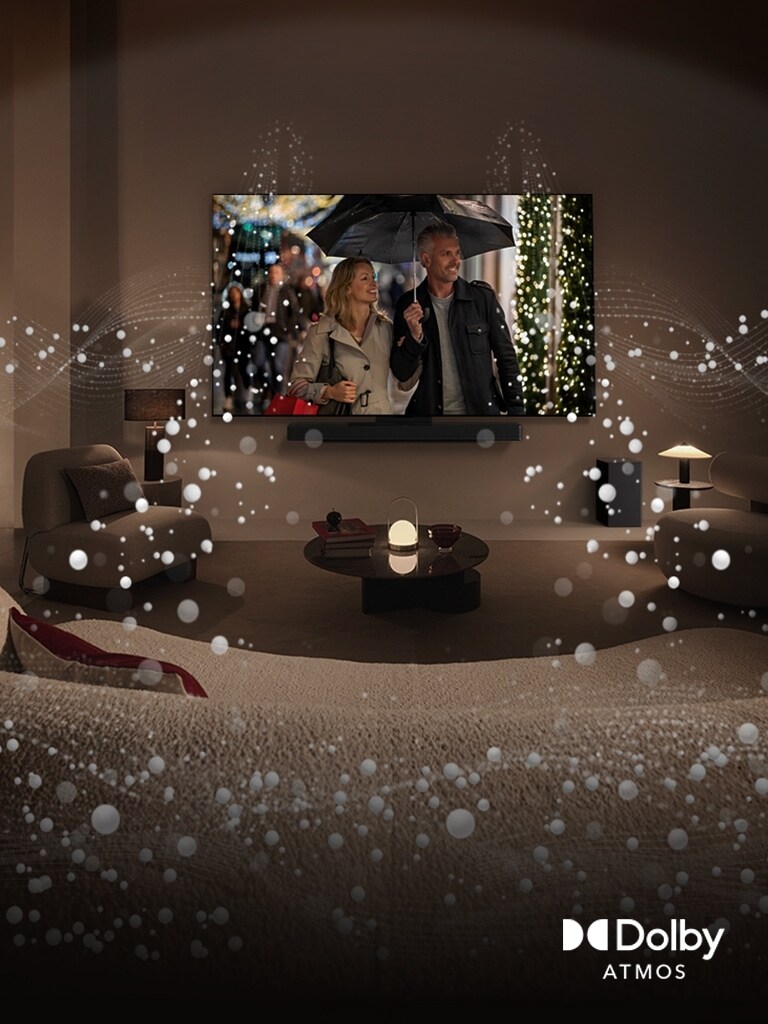 An image of a cozy, dimly lit living space. A scene is being shown on TV where a couple is using an umbrella, and bright circle graphics surround the room. Dolby atoms logo in the bottom left corner.