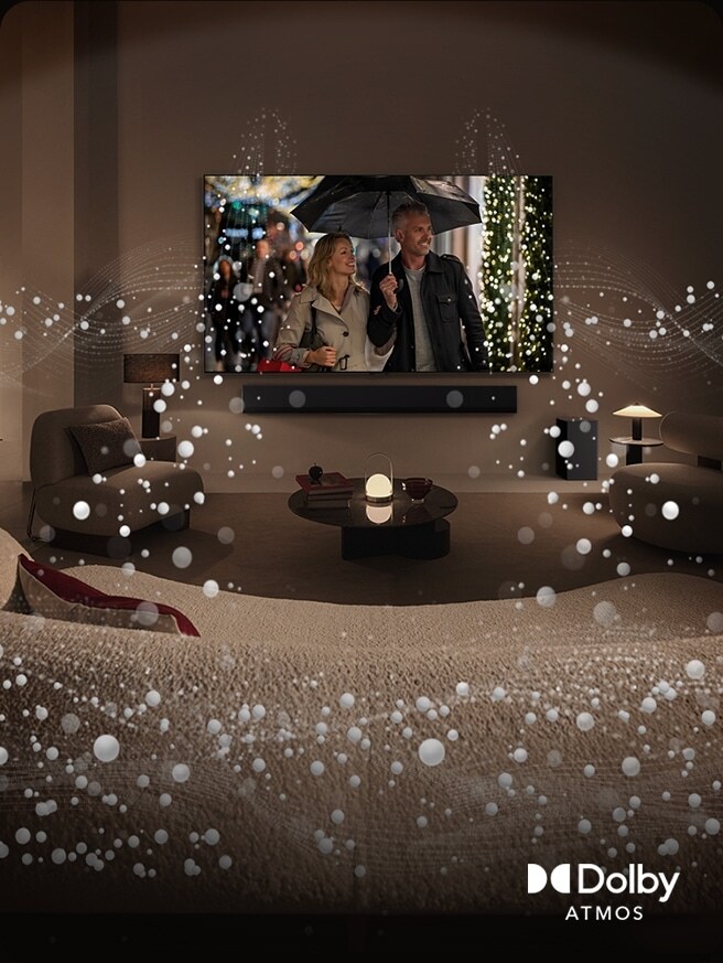 An image of a cozy, dimly lit living space. A scene is being shown on TV where a couple is using an umbrella, and bright circle graphics surround the room. Dolby atoms logo in the bottom left corner.