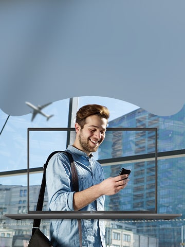 Man in business attire looks at his phone. There is an LG gram laptop in the background.