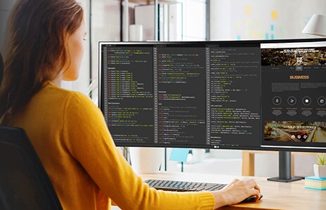 woman works at desk using ergo monitor on code