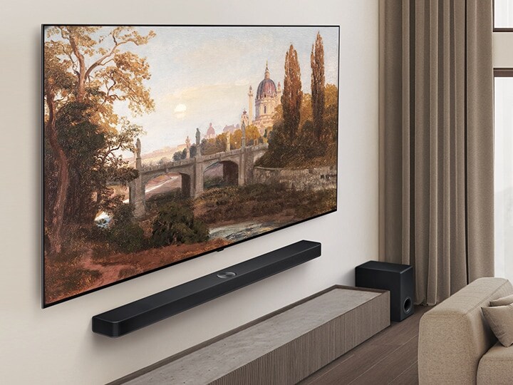 Sala de estar com uma LG OLED TV e uma LG Soundbar montada na parede. A perspectiva está inclinada para mostrar a estrutura fina da TV contra a parede. 
