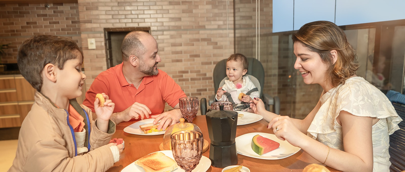 A família juntou-se à mesa, compartilhando uma refeição com sorrisos na cara.