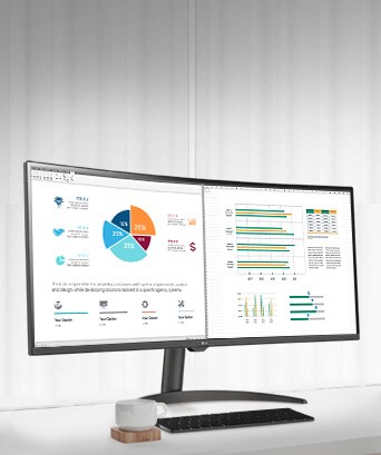 Na mesa, há um monitor inteligente, exibindo um documento de home office sendo trabalhado. À esquerda do monitor, há um copo com alça e, à direita, um telefone celular, um porta-lápis e um suporte.