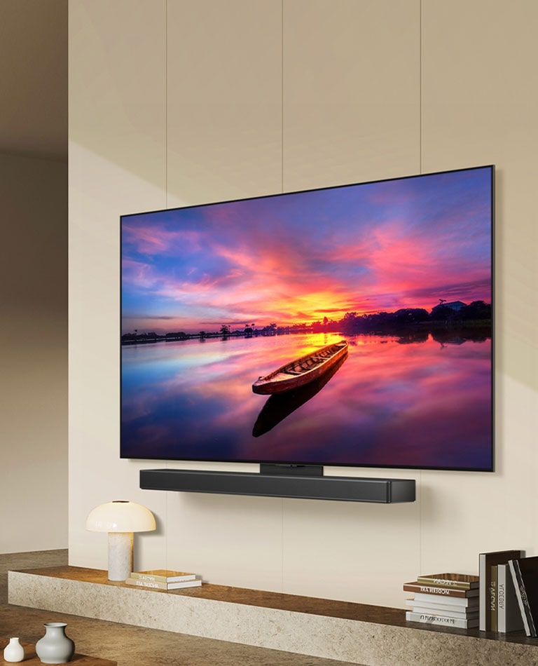 A TV LG OLED evo C4 de design ultra fino voltada para a esquerda está conectada à soundbar por meio de uma suporte de sinergia em um espaço de estar minimalista.