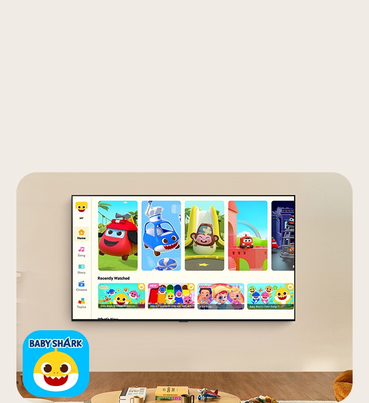 A little boy watches Pinkfong on a wall-mounted LG TV in a living space with kids' toys. 