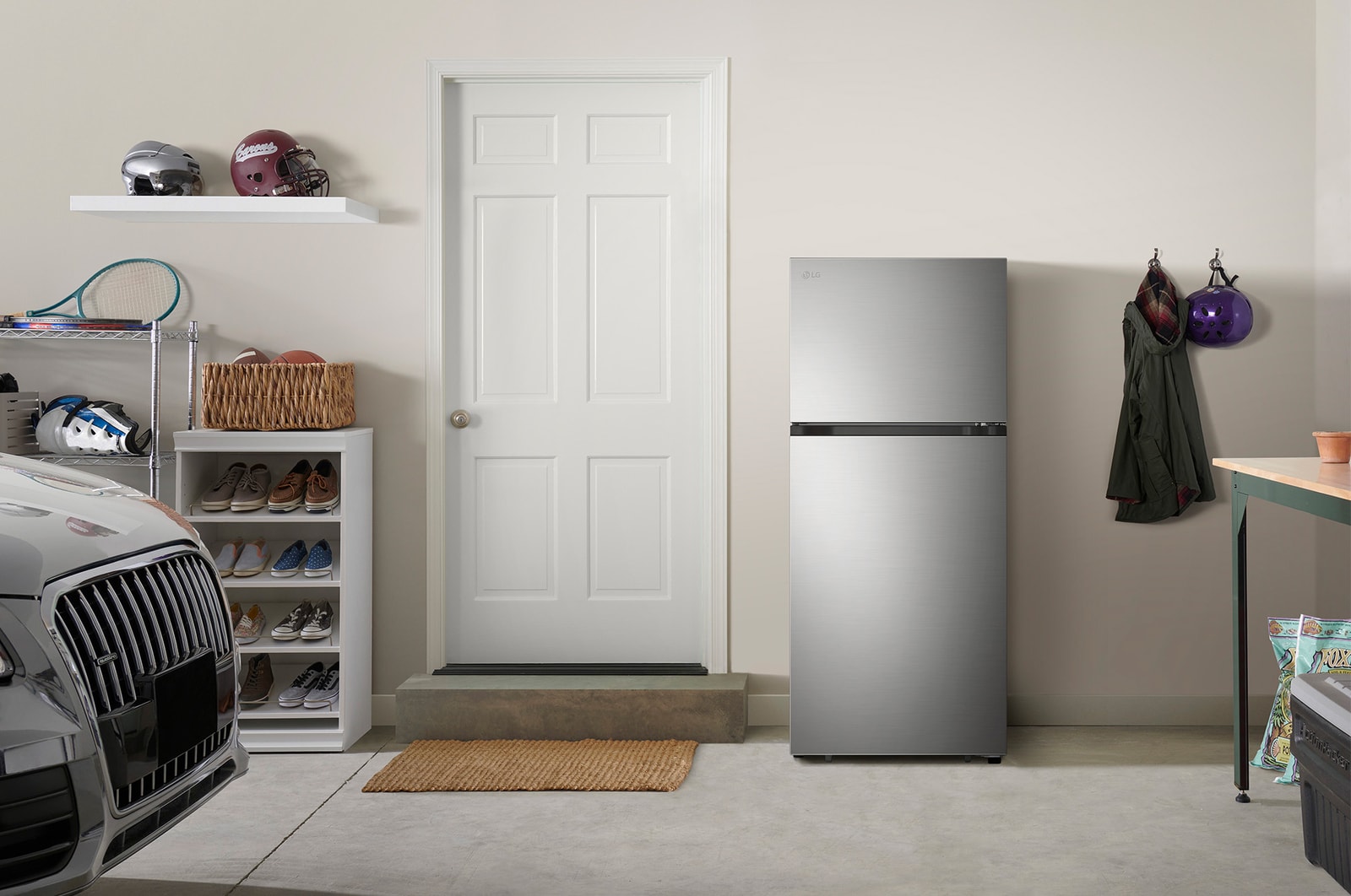 The stainless steel finish LG 28-inch 18 cu.ft. Top Freezer Refrigerator LT18S2100S, shown placed in a garage setting.