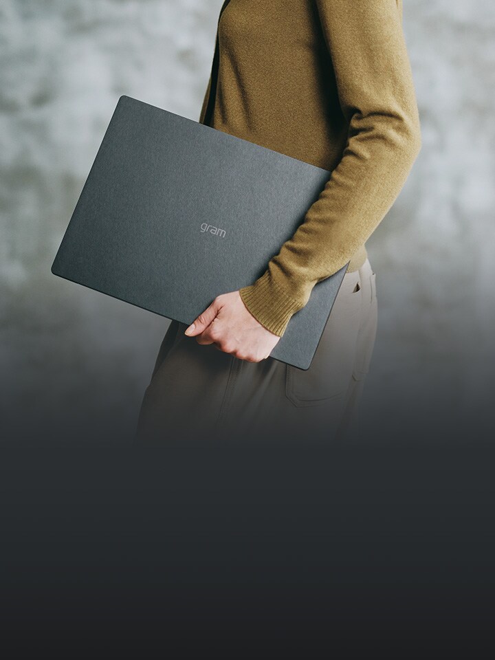 Person holding an LG gram Pro laptop, showcasing its lightweight, durable design and advanced AI-powered performance for exceptional productivity and efficiency.