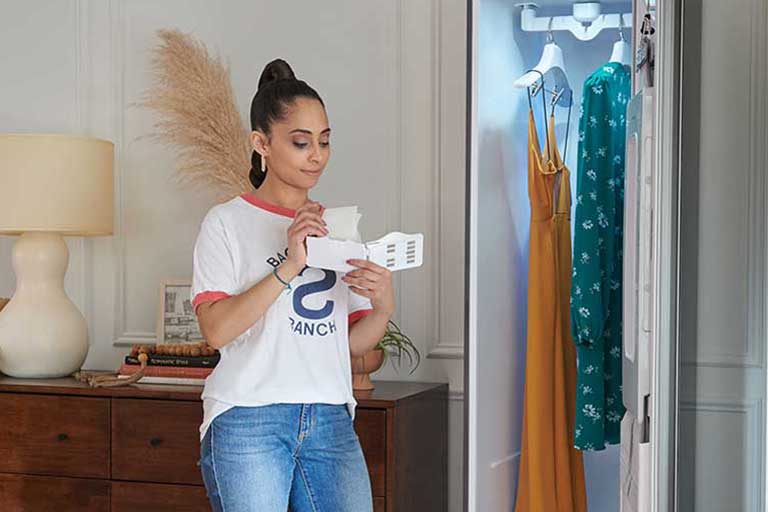 Woman adding dryer sheet to LG Styler to add a pleasant scent to clothes