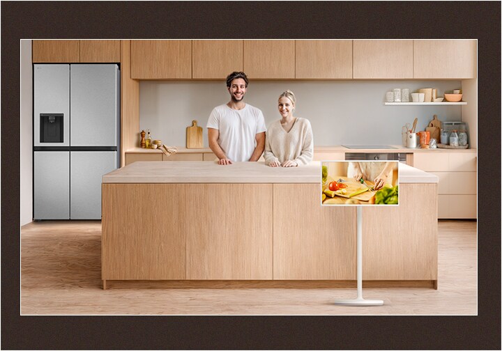 Image of a neat kitchen and a couple looking straight ahead with happy smiles