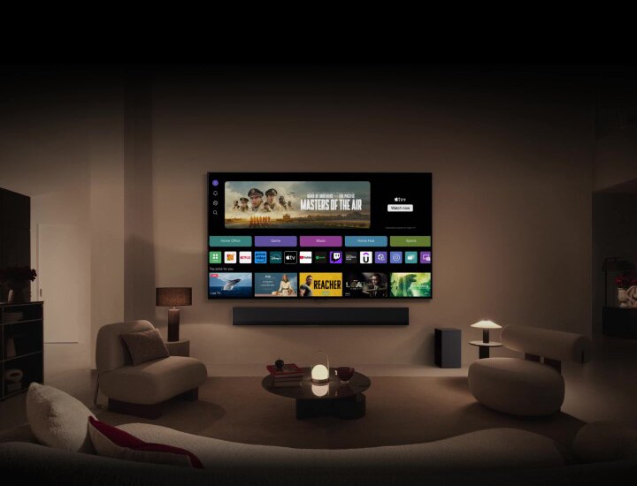 Un gros plan de l’écran d’un LG TV montrant les boutons Home Office, Game (Jeu) et Music (Musique) au-dessus d'une bannière pour Masters of the Air fait un zoom arrière pour montrer le téléviseur monté sur le mur d’un salon. Les logos suivants s’affichent sur l’écran du téléviseur dans l’image : Chaînes LG, Netflix, Prime Video, Disney TV, Apple TV, YouTube, Spotify, Twitch, GeForce Now et Udemy.