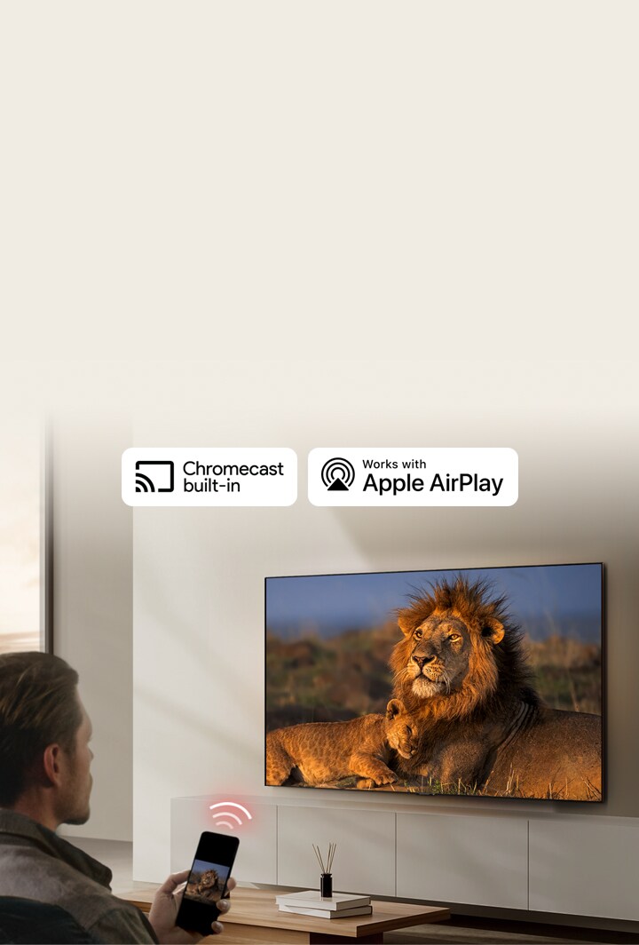 Un LG TV monté au mur d'un salon, montrant un lion et un lionceau. Un homme est assis en avant-plan, un smartphone à la main affichant la même image de lions. Un graphique représentant trois barres incurvées rouge fluo est affiché juste au-dessus du smartphone pointant vers le téléviseur.