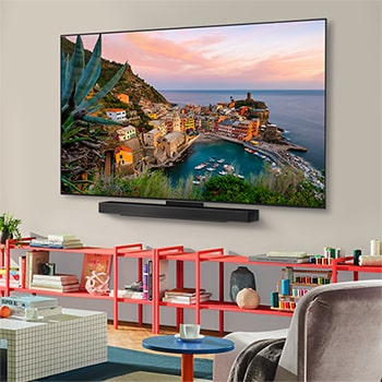 Vue large d’un salon élégant et coloré. Le téléviseur Smart LG OLED evo AI C5 4K est monté sur le mur avec une LG Soundbar en dessous. La conception du téléviseur s’intègre bien à l’espace. L'écran de télévision affiche une œuvre d’art colorée. 