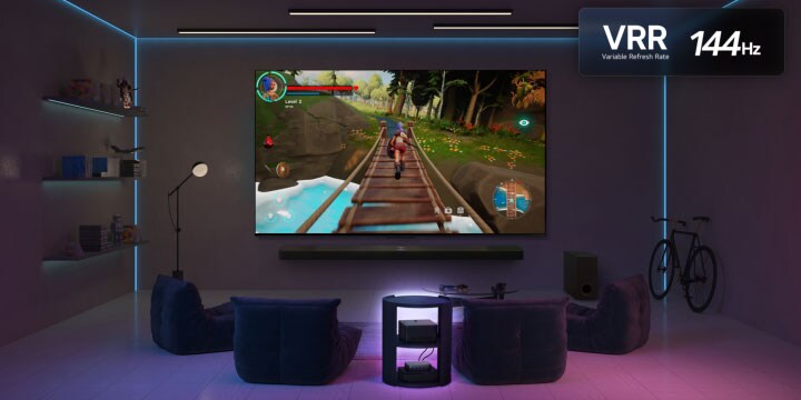 Un salon faiblement éclairé avec un écran de jeu représenté sur le QNED9M. La boîte Zero Connect se trouve à l’intérieur d’une table basse. Le logo VRR et le logo 144Hz sont également visibles.