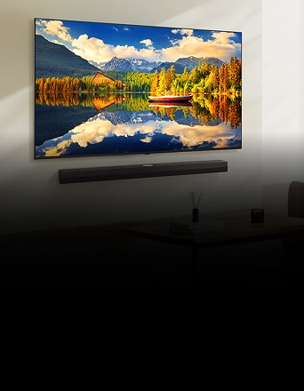 TV NanoCell fixée au mur affichant une vue panoramique lumineuse d’un lac entouré de montagnes, avec un bateau rouge.