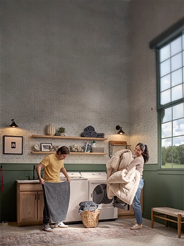 Un couple joyeux fait la lessive ensemble en utilisant leur laveuse à chargement vertical et leur sécheuse de LG dans une salle de lavage lumineuse et élégante. Ils sourient en pliant des serviettes et en déchargeant une couette, illustrant à quel point faire la lessive peut être simple et agréable avec des appareils de LG fiables – idéal pour mettre en avant le service et le soutien de LG.