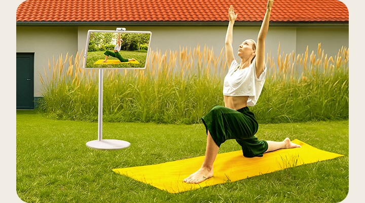Une femme en posture de yoga se reflète sur l’écran du StanbyME 2.