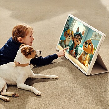 Une fille avec son chiot regarde une émission sur le LG StanbyME 2. La housse folio est utilisée et l’écran est posé en mode tablette.