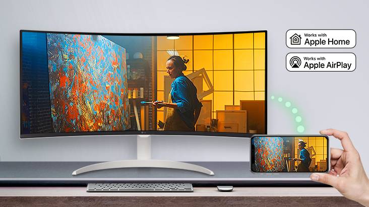 Sur la table, un moniteur affiche une scène d’un film, et la même scène est affichée sur un appareil mobile placé en bas à droite.