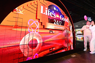 Des visiteurs admirent l'écran LED incurvé de LG présentant le slogan « Life's Good 24/7 » lors d'une exposition technologique.