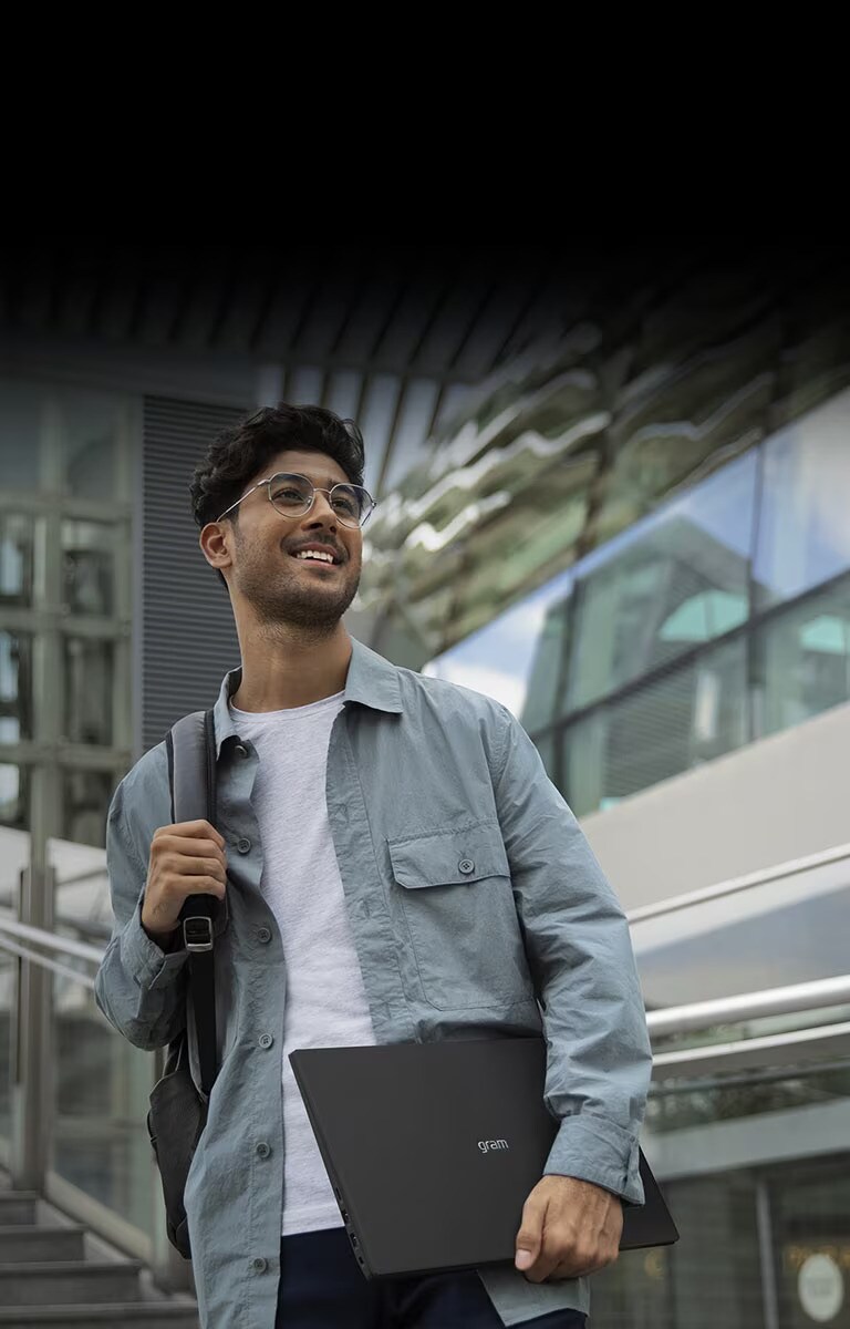 Un homme tient un LG gram et va partout où il veut.