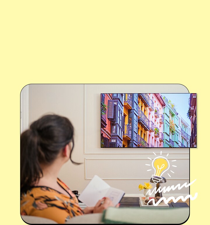 La femme regarde la télévision avec un cahier.
