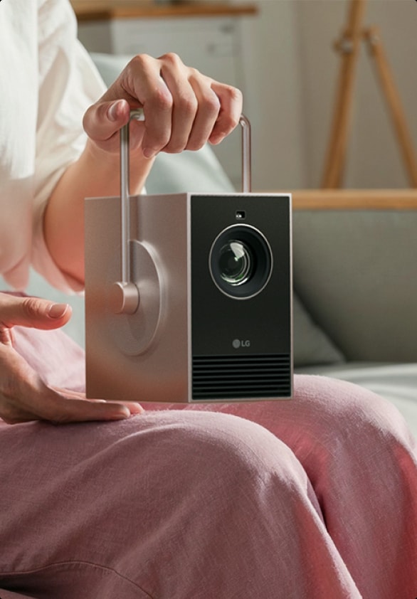 Image d’une personne tenant la poignée pivotante à 360 degrés du LG CineBeam Q.