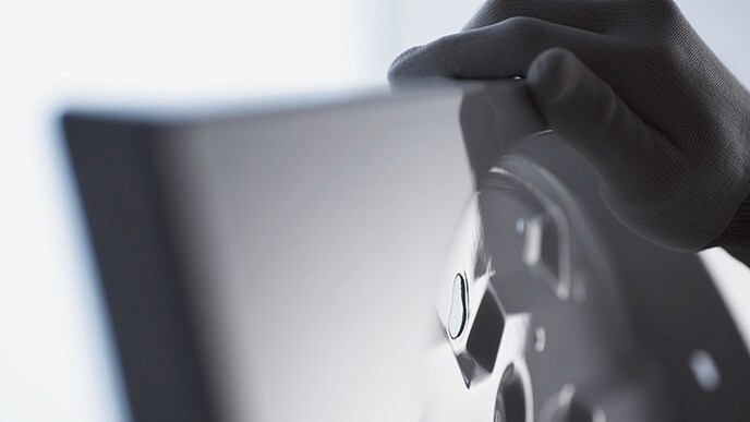 Eine Hand eines Handwerkers berührt den emaillierten Körper der LG SIGNATURE Washing Machine.