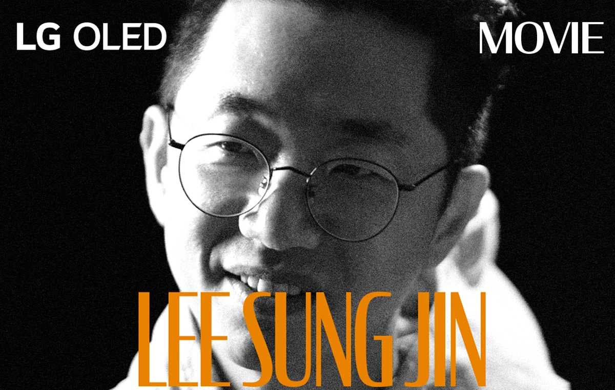 Une image fixe en noir et blanc tirée d’une interview avec Lee Sung Jin. Son nom apparaît en gras et en orange en bas du cadre. L’indication LG OLED se trouve dans le coin supérieur gauche et le mot film se trouve dans le coin supérieur droit.