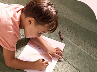 Niños escribiendo tarjetas para su mamá y lavando, junto a su papá, la ropa manchada de crayones usando el LG WashTower.