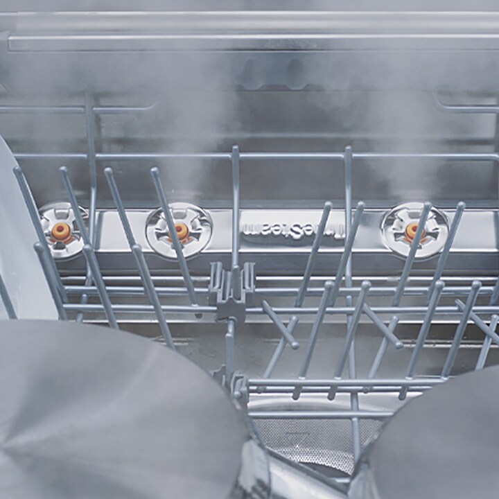 Primer plano de varios tipos de vajilla lavados al vapor en el lavavajillas.