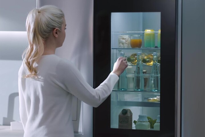 Video: mujer se acerca al refrigerador InstaView, toca dos veces la puerta. Interior se ilumina y se ve sin abrir la puerta.