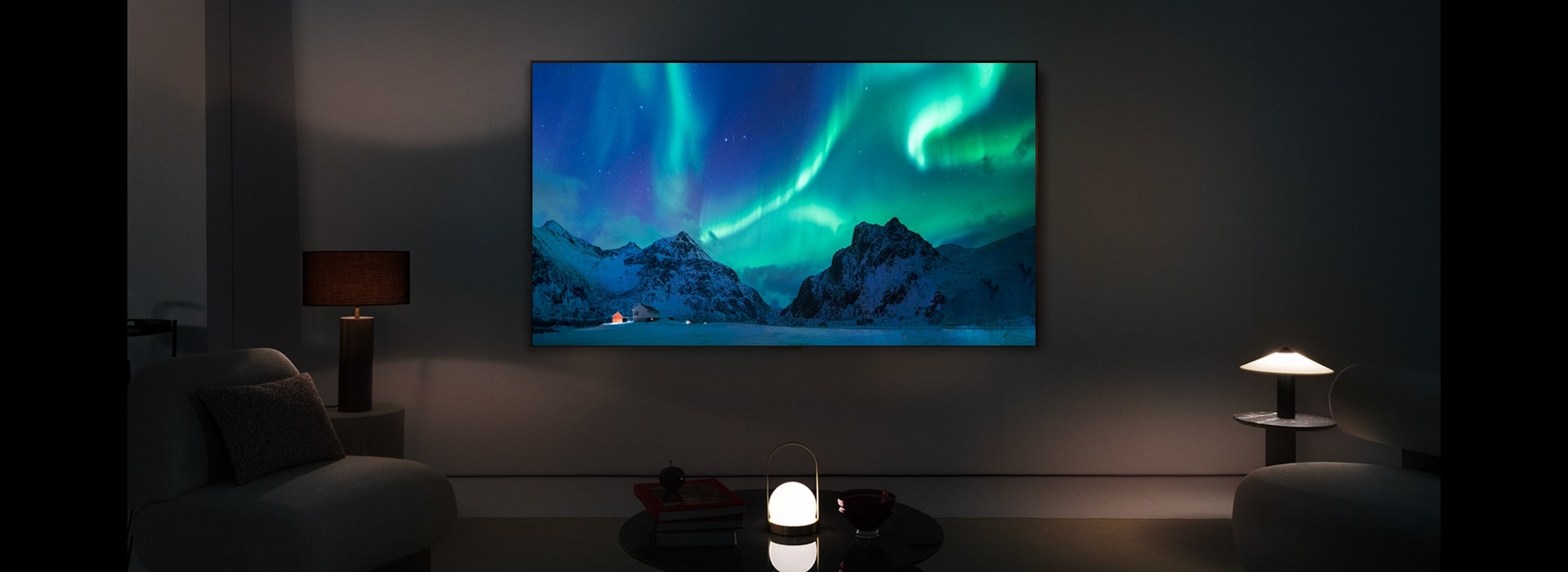 El televisor LG OLED y una barra de sonido LG en un espacio moderno durante la noche. La imagen de la aurora boreal se muestra con los niveles de brillo ideales.