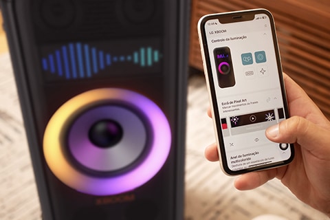 Un hombre configura el altavoz LG XBoom desde su móvil, ajustando la iluminación y creando arte pixelado.