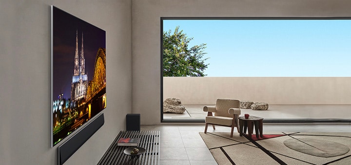 Salón con televisión wall-mounted LG OLED G5 y LG Soundbar vistos desde un lado. Este ángulo destaca su Diseño para una pared y cómo sus biseles y el diseño quedan al ras de la pared. 