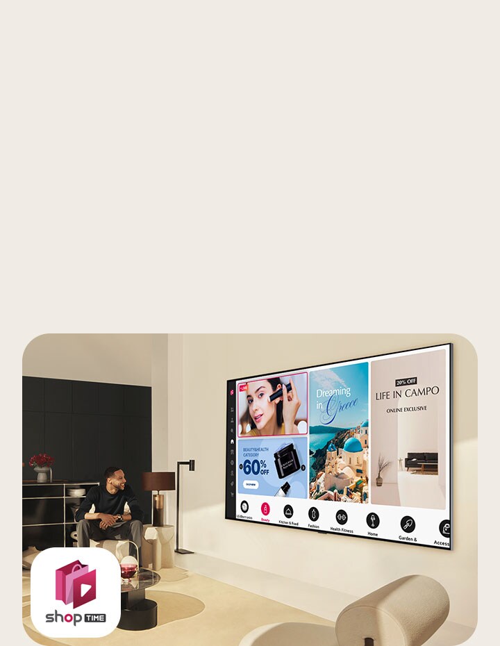 Una pareja mira los canales de televenta en un gran LG TV montado en la pared de una moderna sala de estar. 