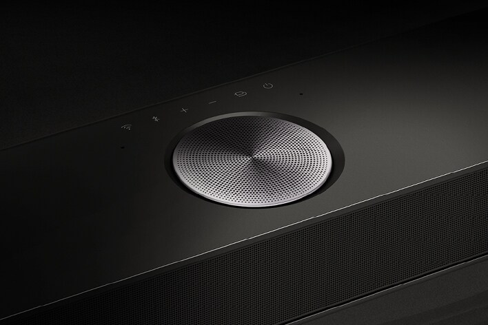 Detail jednoho z reproduktorů na zařízení LG Soundbar. Nad reproduktorem jsou vidět ovládací prvky soundbaru. 