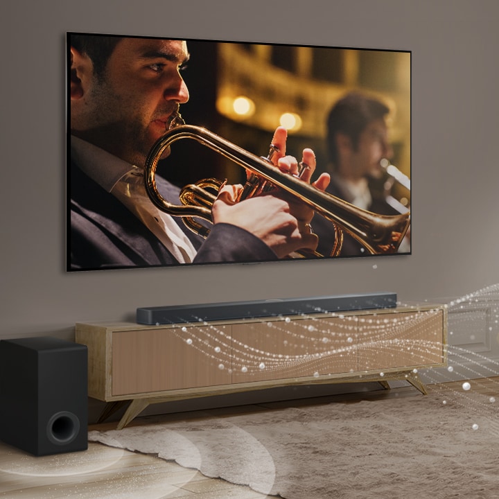 LG TV, LG Soundbar a subwoofer jsou umístěny v moderním městském bytě. LG Soundbar vysílá zvukové vlny tvořené bílými kapkami, které zaplňují místnost, a subwoofer vytváří zvukový efekt zespodu. Jako celek vytvářejí v místnosti kopulovitý efekt.