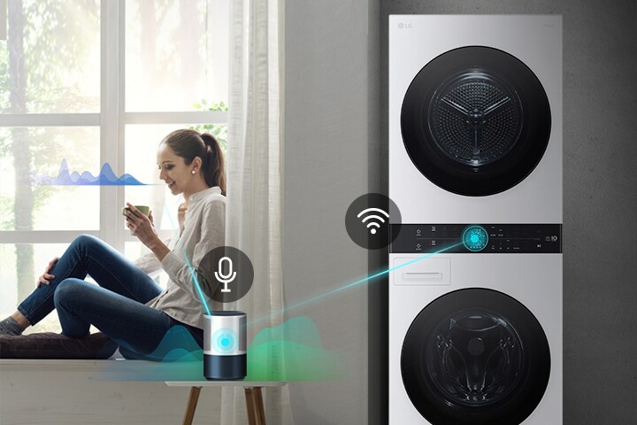 Žena sedící u okna ovládá pračku LG WashTower a sušičku pomocí hlasového asistenta a Wi-Fi připojení.