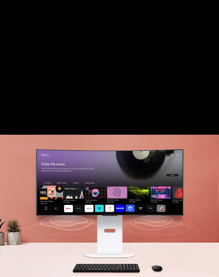 Na chytrém monitoru umístěném na stole je vidět obrazovka aplikace HUDBA.