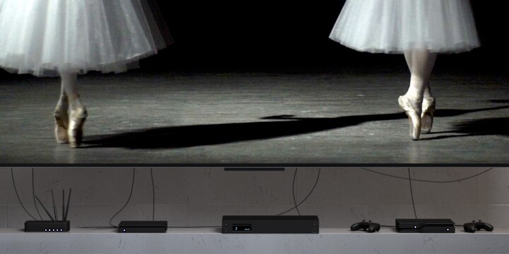 Man sieht ein unordentliches TV-Setup, alle Peripheriegeräte unter dem Fernseher beinhalten viele Kabel. Das Setup verschwindet plötzlich und gibt den Blick auf einen LG True Wireless TV frei. Keine Kabel sind zu sehen.