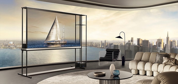 LG OLED T4 in einer Penthouse-Wohnung. Die Fenster geben den Blick auf die Skyline der Stadt und das Meer frei. Der LG OLED T4 zeigt im transparenten Modus das Bild einer Yacht. Durch die Position des Fernsehgeräts und die Transparenz des Bildschirms wirkt es, als würde die Yacht draußen auf dem Meer schwimmen.