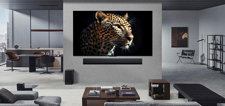 LG OLED M5 TV und LG Soundbar montiert an der Wohnzimmerwand einer gehobenen Wohnung. Die Zero Connect Box steht versteckt unter einem Beistelltisch.